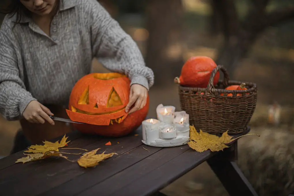 a woman carving a pumpkin