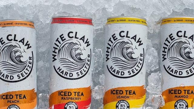 cans of white claw hard seltzer iced tea lemon raspberry mango peach above ice