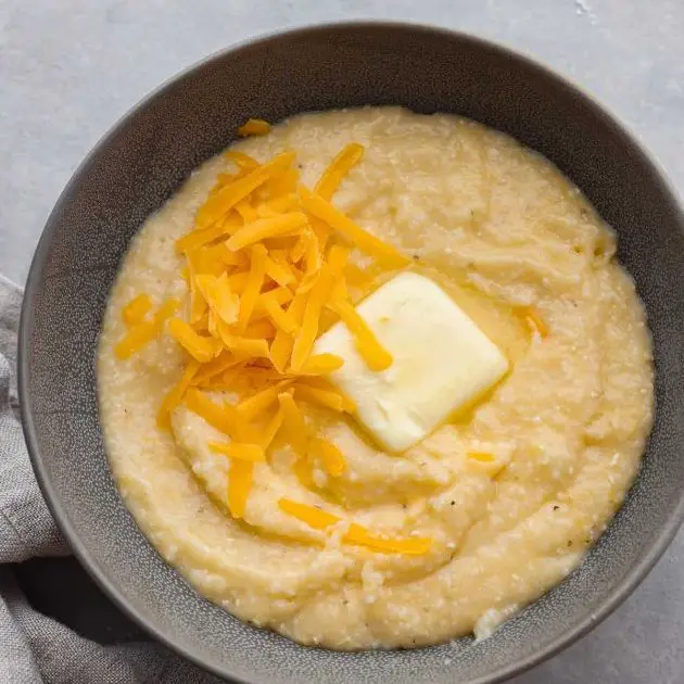 grits topped with shredded cheese served in a bowl