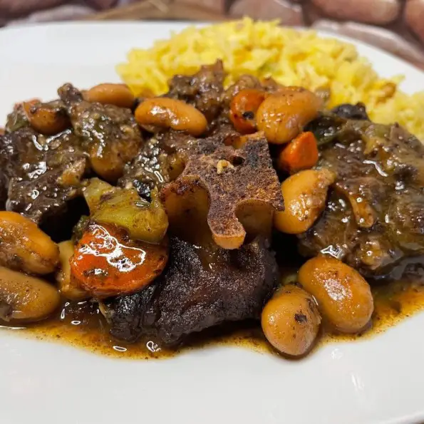 jamaican oxtail stew topped with butter beans and carrots served in a plate