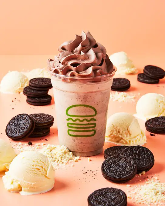 shake shake oreo shake with pink background with some scoops of vanilla ice cream and Oreos beside it