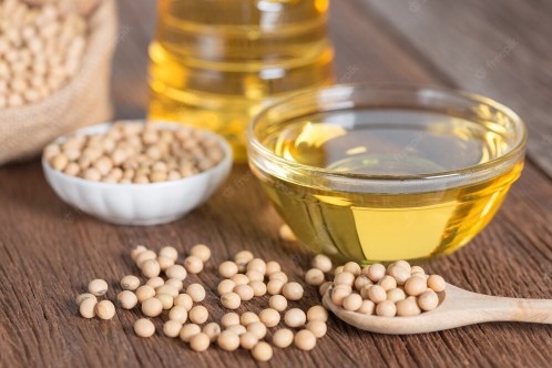 soy bean oil and soybeans placed on a wooden table
