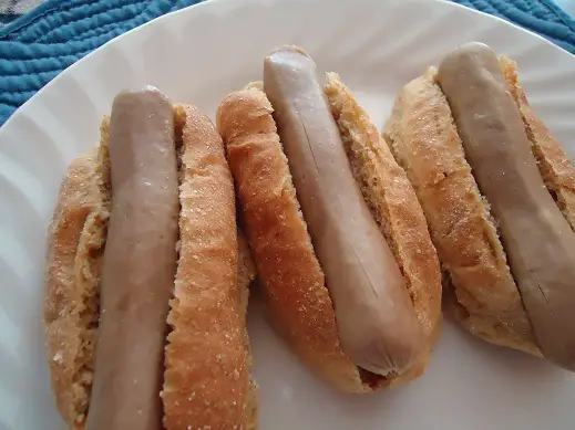 three grey hotdogs served in a plate