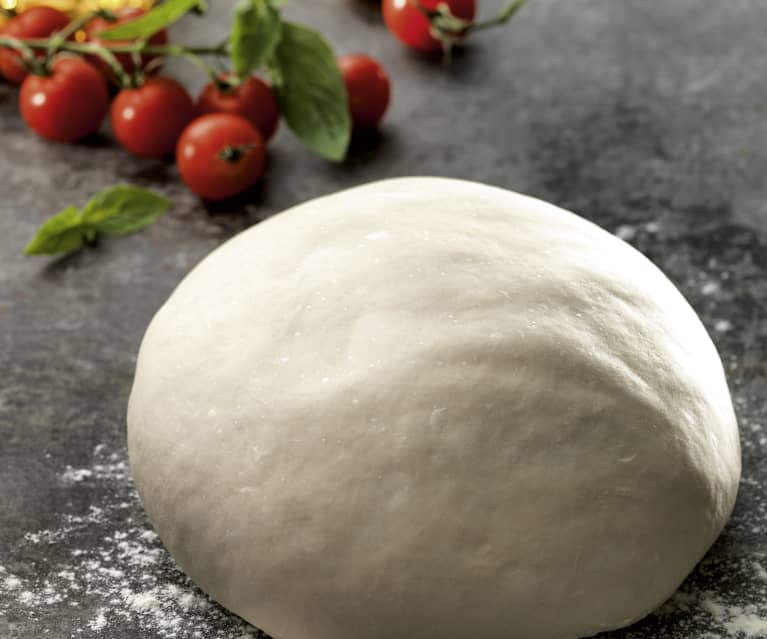 fluffy dough with some cherry tomatoes in background