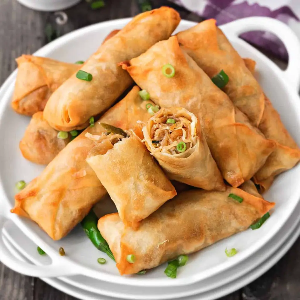 spring rolls served with some green onions sprinkled on it 